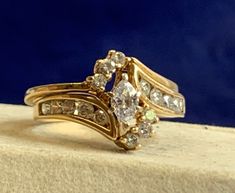 a gold ring with three stones on top of it, sitting on a stone block