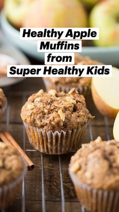 muffins cooling on a rack with apples and cinnamon sticks in the back ground