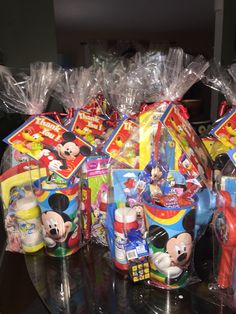 plastic bags filled with mickey mouse toys on top of a table