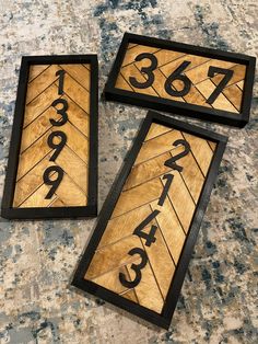 two wooden signs with numbers on them sitting on a counter top next to each other