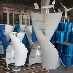 several white and blue vases sitting on pallets in a room with metal racks