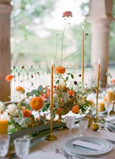 the table is set with flowers and candles