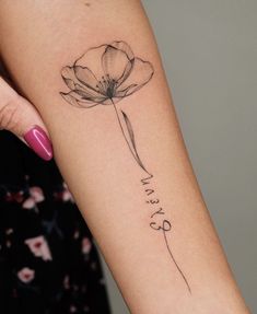 a woman's arm with a single flower tattoo on the left side of her arm