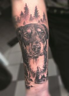 a man's arm with a dog and trees on it