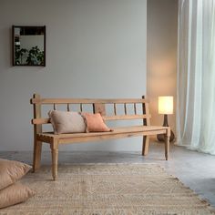 a wooden bench sitting on top of a rug in a living room next to a window