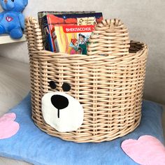 a basket with a stuffed bear and books in it