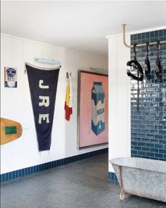 there is a bathtub in the bathroom with two umbrellas hanging on the wall