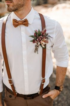 a man wearing a bow tie and suspenders with a flower in his lapel