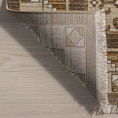 an area rug with fringes on the top and bottom of it, sitting on a wooden floor