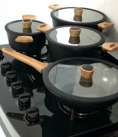 pots and pans are sitting on top of an electric cooktop with wooden handles