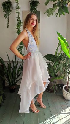 a woman in a white dress posing for the camera with her hands on her hips