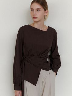 This is a refined and modern blouse by ourcomos that is made out of high quality and sturdy material. With distinctive mood of the design and comfortable wear, you can style it for your stylish and modern daily outfit.- Unbalanced diagonal neckline point- Back zipper for comfortable wear- Luxurious sea shell buttons Modern Brown Tops For Workwear, Modern Brown Top For Work, Elegant Brown Top For Work, Asymmetrical Blouse For Work In Fall, Chic Brown Blouse For Work, Chic Brown Workwear Blouse, Fall Asymmetrical Workwear Blouse, Fitted Brown Wrap Top, Chic Brown Tops For Workwear