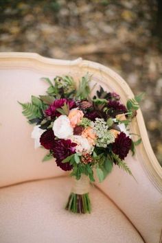 a bridal bouquet sitting on an old chair