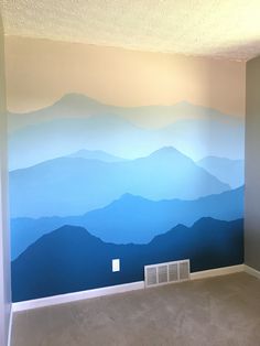 an empty room with mountains painted on the wall