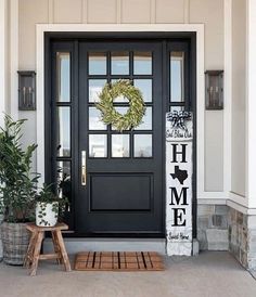 a black front door with a wreath on it