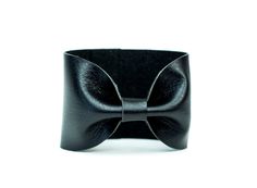 "Noir Black Bow Tie Vegan Leather Wide Cuff Bracelet by ForgottenCotton Because we know that Bow Ties are cool. Our noir black bow tie cuff is perfect 'oh so adorable' accessory. Dressed up or down, it is versatile, cute, and sure to get tons of compliments. Why we love it: Our cuffs are made to be versatile. You can wear our cuffs on either your wrist or your scarf (or both!) We chose high quality vegan leather that has the look and feel of leather without the guilt. Hand stitched to perfection Chic Adjustable Leather Bracelet For Parties, Black Band Bracelets For Party, Black Band Bracelet For Party, Adjustable Wrist Strap Wristlet For Party, Adjustable Wristlet With Wrist Strap For Party, Adjustable Black Wristlet For Party, Adjustable Elegant Leather Bracelet For Party, Adjustable Black Wristlet With Bracelet Strap, Black Cuff Leather Bracelet For Party