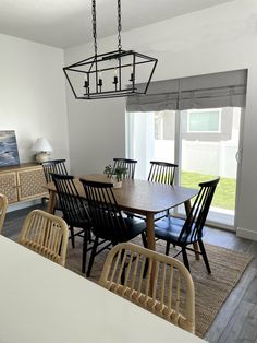 a dining room table and chairs in front of a sliding glass door