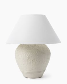 a white ceramic lamp with a white shade on it