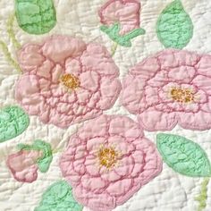 a pink and green quilt with flowers on it