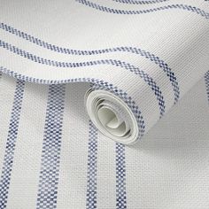 a white and blue wallpaper with checkered design on it's side, next to a roll of toilet paper