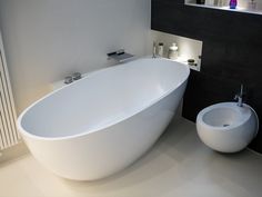 a large white bath tub sitting next to a sink