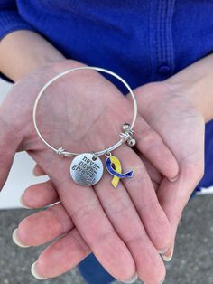 "Blue/Yellow Ribbon charm Bangle Bracelet - Adjustable Expandable Wire Bangle Bracelet - Never Give Up Engraved Metal Plate Charm Bangle Expandable Wire Bangle Bracelet With Down Syndrome Awareness Ribbon charm , \" Never Give Up\" Engraved Metal Plate Charm and Beaded Dangles. Weight Around 11.5g, diameter 2.35in, engraved disc measures 0.75in. Ribbon Charm 21mm x15mm. This Bangle can be expanded to 2.85in to adjust girls wrists. *Support friends and family who's going through tough time now. R Adjustable Yellow Round Bangle, Adjustable Yellow Hypoallergenic Bracelets, Adjustable Yellow Charm Bracelet As A Gift, Adjustable Yellow Charm Bracelet For Gift, Adjustable Yellow Charm Bracelet Gift, Adjustable Yellow Bangle For Gift, Yellow Friendship Bangle Jewelry, Adjustable Yellow Bracelets With Lobster Clasp, Yellow Metal Bangle Bracelet