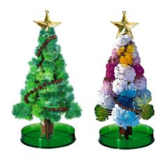 two plastic christmas trees on green bases with gold stars