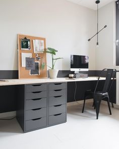 an office with a desk, chair and pictures on the wall above it is shown