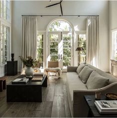 a living room filled with furniture and large windows