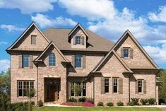 a large brick house with lots of windows on the front and side of it's roof