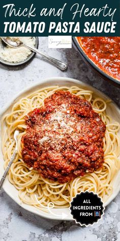 a white plate topped with spaghetti and sauce next to a pot of tomato sauce on the side