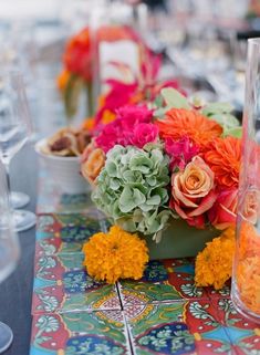 an arrangement of flowers and candles on a table