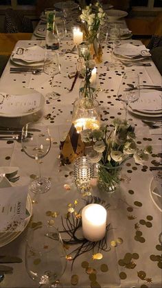 a long table is set with white and gold confetti, candles, and flowers