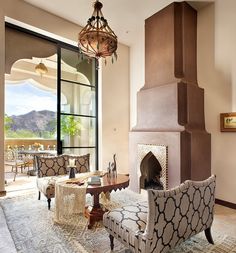 a living room filled with furniture and a fire place in front of a glass door