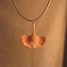 a necklace with a leaf hanging from it's side