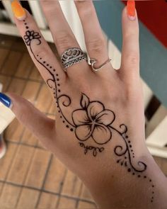 a woman's hand with a flower tattoo on the middle of her left hand