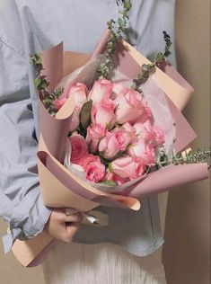 a person holding a bouquet of pink roses