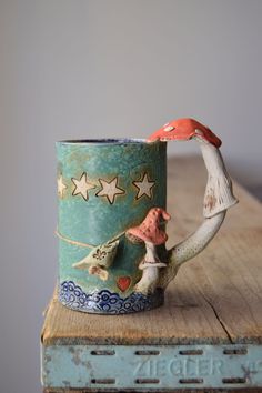 a coffee cup with a bird on it sitting on top of a wooden table