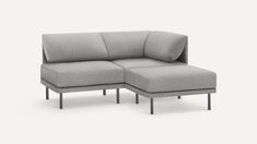 a gray couch with a small foot rest on the bottom and one arm folded over it