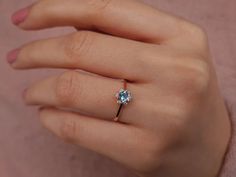 a woman's hand with a diamond ring on it