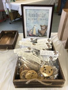 some cookies are in a wooden box on a table next to a sign that says please don't go