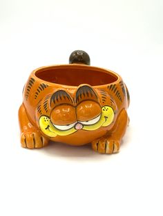 an orange ceramic cat planter sitting on top of a white surface