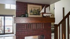 a living room with a fire place and a sailboat on the fireplace mantel