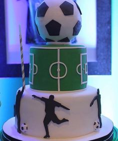 a three tiered cake with a soccer theme on it