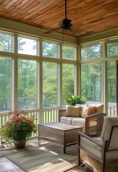 a sun room with large windows and wicker furniture on the front porch, along with potted plants