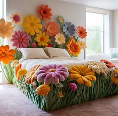 a bed made out of fake flowers in a room with a large window behind it