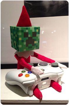 an elf with a video game controller in front of him on a table next to a wall