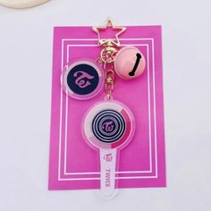 a pink key chain with two different items on it and a star hanging from the top