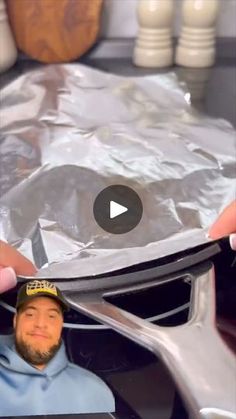 a man is holding up a piece of tin foil to show how it looks like