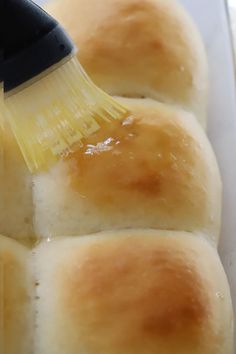 a close up of bread rolls being brushed with a brush